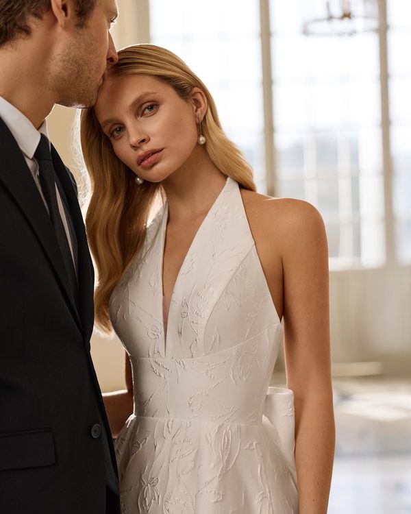 BONY - Vestido de novia con escote pico y espalda abierta. Silueta línea A en brocado con lazo en la falda. 1