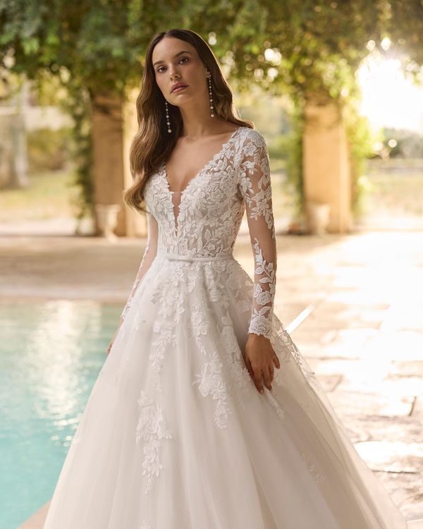 XIARA - Robe de mariée princesse en tulle glitter avec décolleté profond, dos illusion boutonné, manches longues avec appli... 1